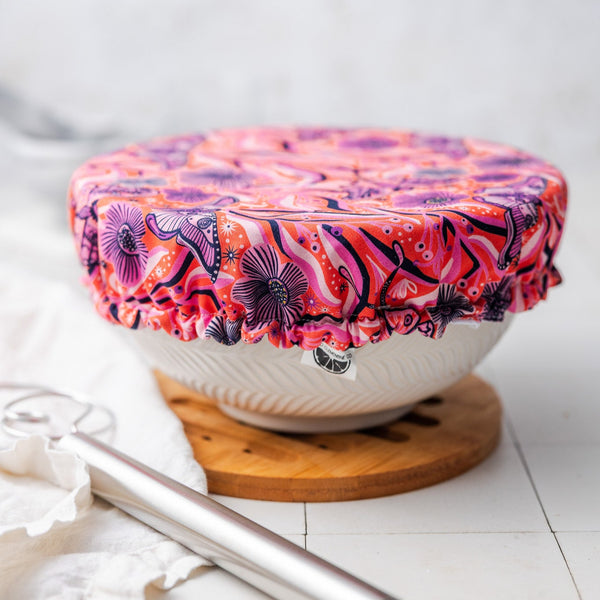 White bowl with a colorful floral cover on a white surface