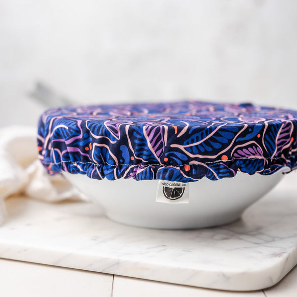 White bowl with a blue and pink floral cover on a marble surface
