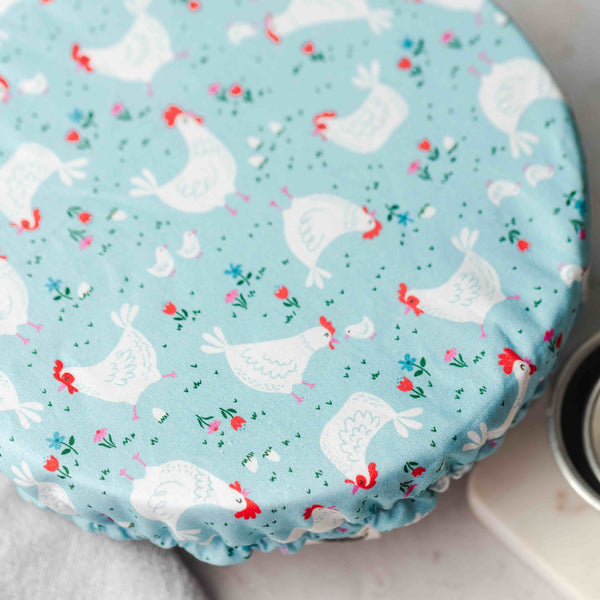 Round blue fabric cover with chicken pattern on a light background