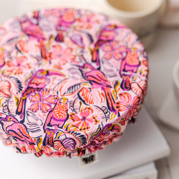 Colorful fabric-covered dish on a white surface with a cup in the background
