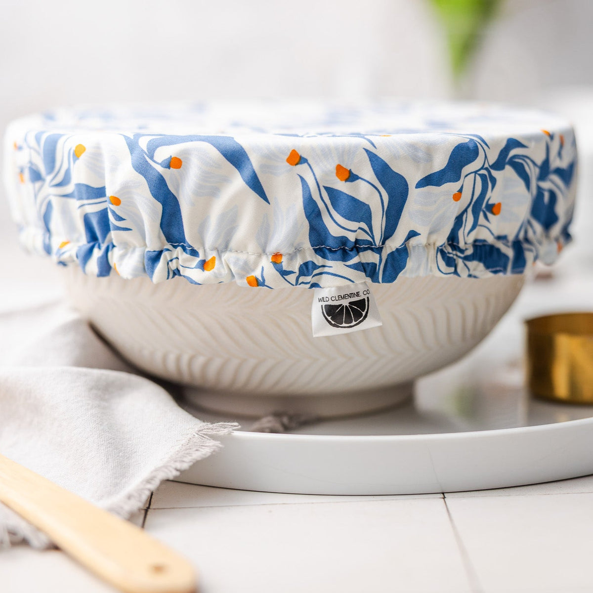 White bowl with blue floral pattern dish cover on a white surface