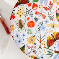 Eco-friendly reusable dish cover, white with images of flowers, moths, butterflies, stinkbugs, etc.