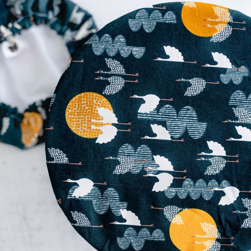 Deep cobalt blue reusable bowl cover with cranes flying amongst clouds and moons print