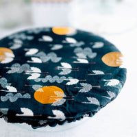 Deep cobalt blue reusable bowl cover with cranes flying amongst clouds and moons print