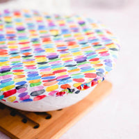 White reusable bowl cover with rows of watercolor rainbow dashes