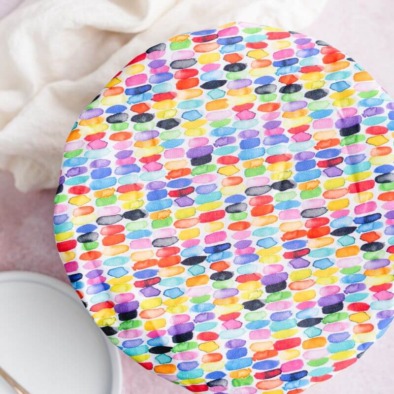 White reusable bowl cover with rows of watercolor rainbow dashes