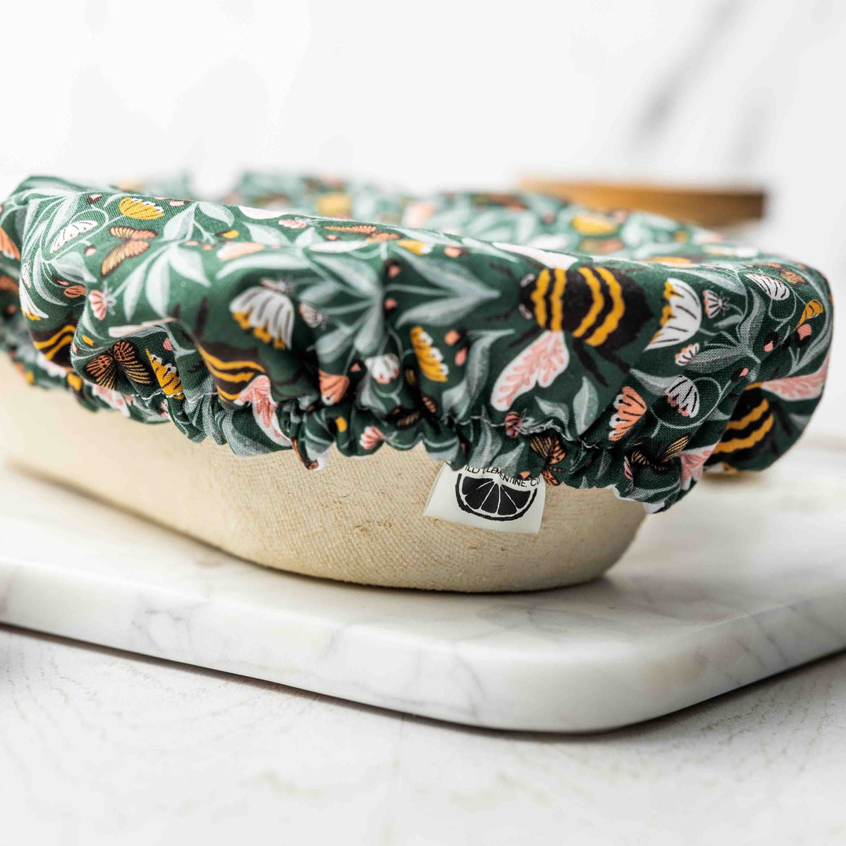 Floral-patterned cover on a white container with a marble surface background