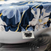 Floral-patterned tablecloth with a brand label on a white surface