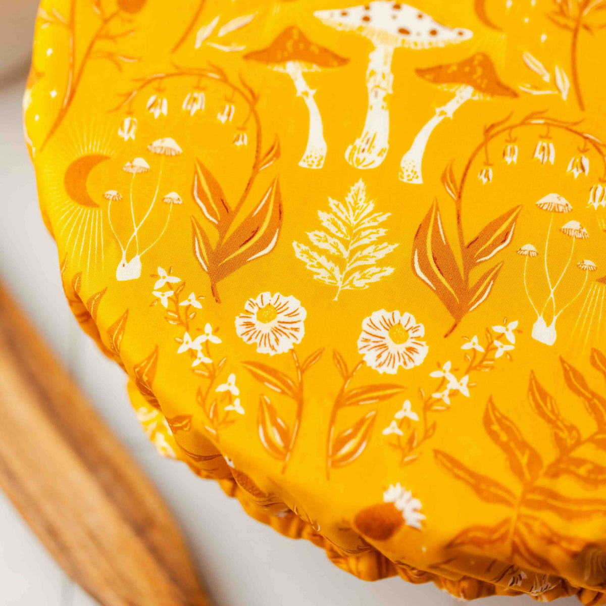 Yellow pie dish with white floral and mushroom pattern on a white background
