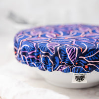 Blue and pink patterned lid on a white container with a blurred background