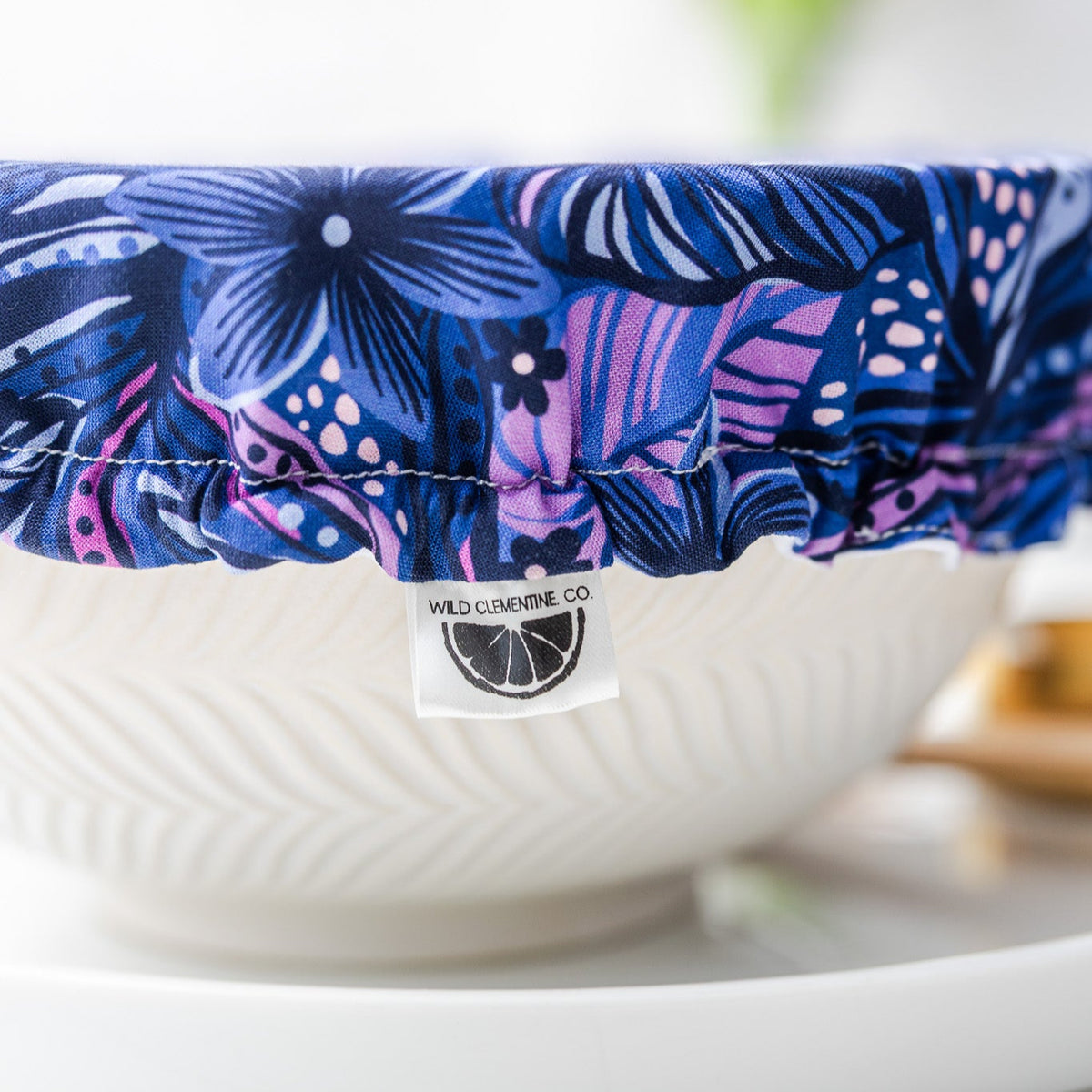 White bowl with a blue floral cover on a white surface