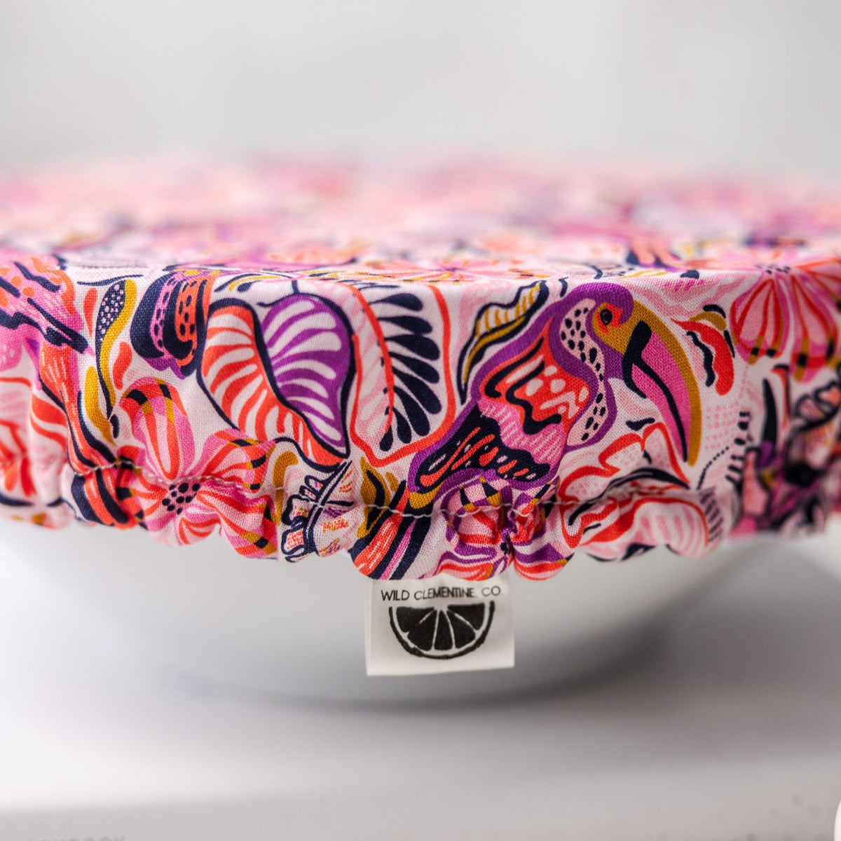 Colorful dish cover with a brand label on a white surface